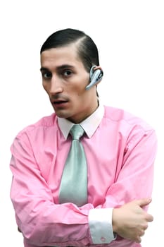 Young handsome  confident  businessman with hands on bosom on white background.  He speaks on telephone through headset "blue tooth".