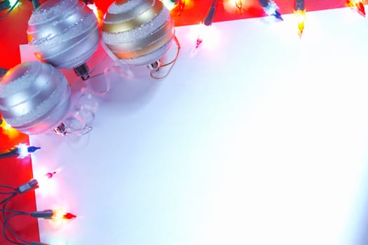 New Christmas baubles border with holiday lights with a white background and copy space.