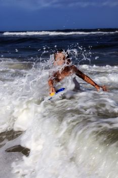 a young boy gets hit by a big wave in florida