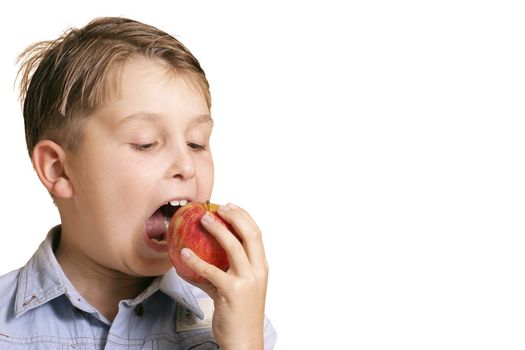 Boy biting a juicy red apple