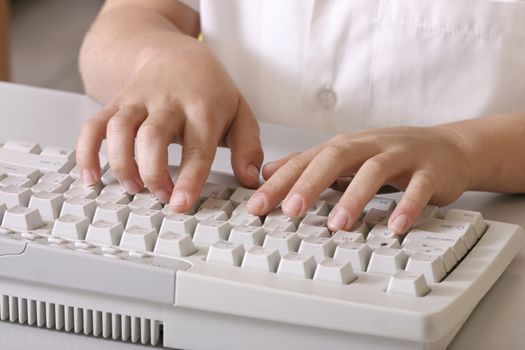 child typing on a computer keyboard