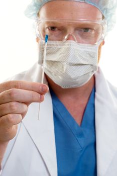 A man holding a swab.  Focus on hand and the swab.