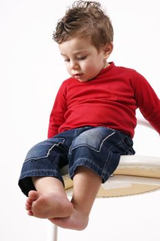 Toddler sitting  on a high stool makes an observation of his surroundings