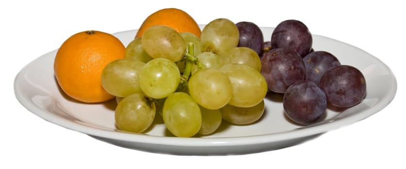 Red and white grapes are on a platter with a tangerine.