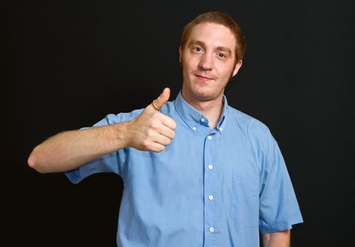 smiling young man with thumbs up 