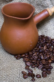 Ceramic Coffee Pot and Coffee Beans on Linen Background