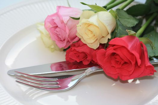 Different roses on a place setting, perfect for a dinner invitation