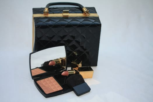 A ladies purse and luxury make up. blusher and lipstick