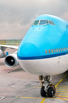 Blue and white landed aircraft docked in airport