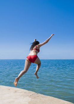 A woman photographed leaping into the sea.