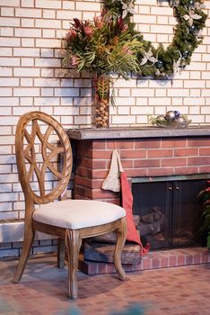 A cozy view of a wooden chair sitting by a brick fireplace