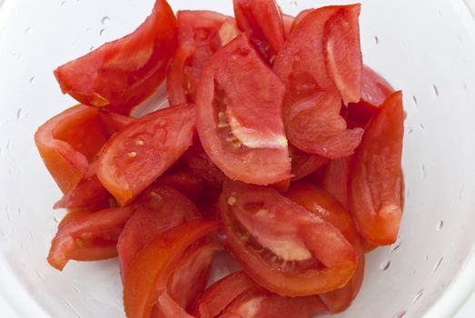 Slices of fresh tomato in white bowl