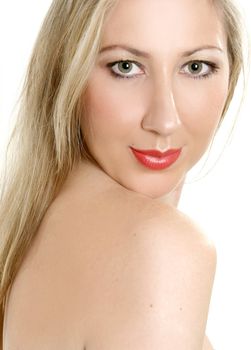 Fresh faced, beautiful woman with green eyes and long blonde hair looking over bare shoulder