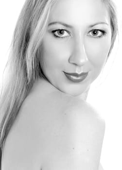 Fresh faced, beautiful woman with green eyes and long blonde hair looking over bare shoulder