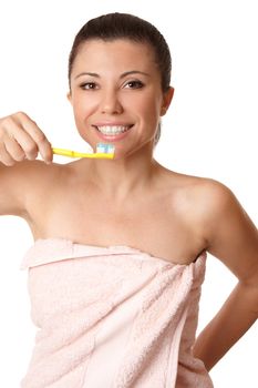Smiling woman holding a toothbrush with toothpaste about to brush her teeth.