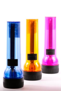 Three colorful flashlights on white.