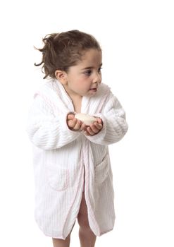 A young girl holding soap is looking sideways with some space for copy...