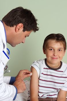 A doctor gives a child a vaccine or flu shot in the arm.   
