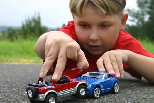 A boy playing with toy cars