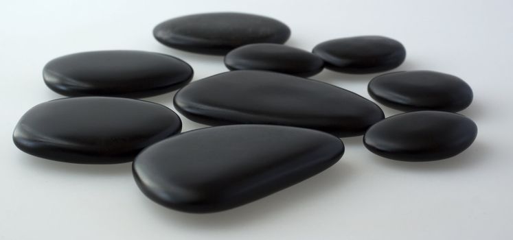 Black basaltic stones for massage over gray background