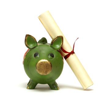 An isolated shot of a piggy bank and diploma scroll for saving for an education.