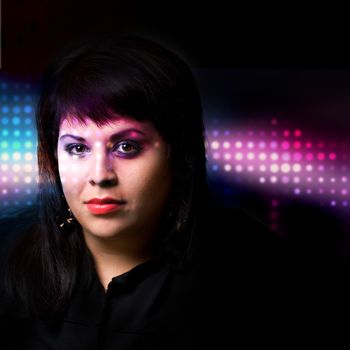 Portrait of a young woman under dramatic lighting with colorful abstract effects.