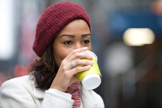 A modern business woman in the city  enjoying a cup of coffee hot chocolate latte or tea.
