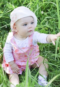 Curious baby girl on grass