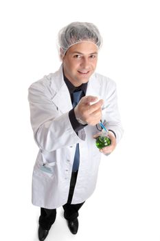 A scientist, pharmacist or other laboratory worker adds a measured sample to a flask of liquid.