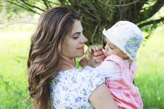 Baby girl with her mother giving a flower