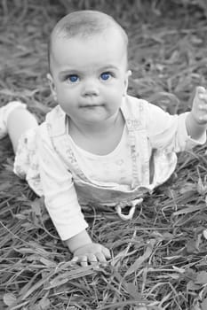 Happy baby girl lying on grass