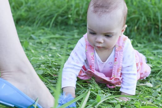 Curious baby girl lying on grass