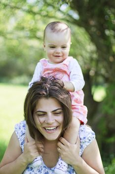 happy mother with her child on her shoulders