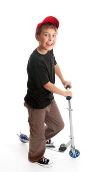 A boy stands beside his scooter.   He is  looking up and smiling happily.