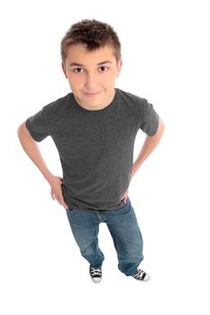 A pre teen boy standing with his hands on hips.  He is wearing a grey marle t-shirt and blue jeans.