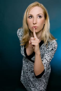 A female gestures for silence or secrecy