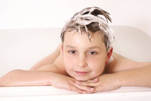 Boy in the bath tub with sudsy hair