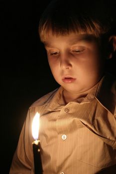 Boy lit by candlelight at night 400iso 