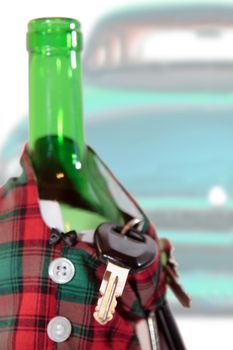 bottle dressed in jacket warmer with keys and alcohol with a car in background depicting drunk driving and addictions can kill