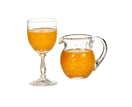 Cut glass isolated goblet and jug filled with fresh orange juice