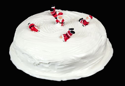 A traditional british xmas cake. Toy Santa are playing on the icing.