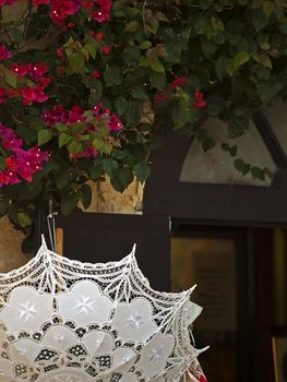 Detail of parasol in Malta lace showing Maltese cross and door in old city of Mdina in Malta