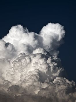 Towering detailed cumulus cloud with lenticular formations