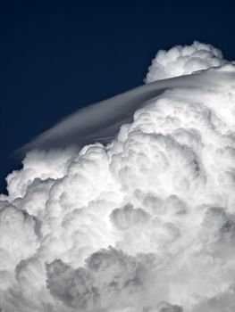 Towering detailed cumulus cloud with lenticular formations