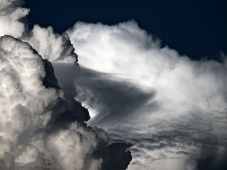 Towering detailed cumulus cloud with lenticular formations