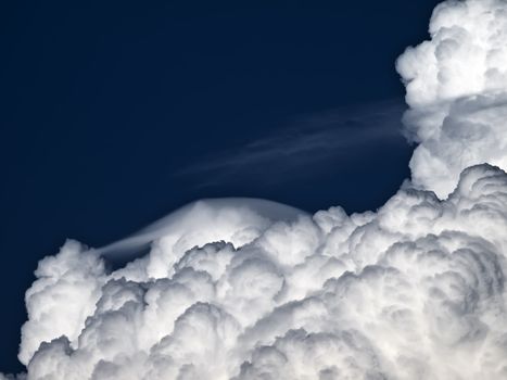 Towering detailed cumulus cloud with lenticular formations