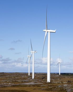 Winding road connecting row of windmills in Smola, Norway. 