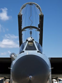 Frontal view of a Tornado jet fighter with pilot's helmet lying on open canopy