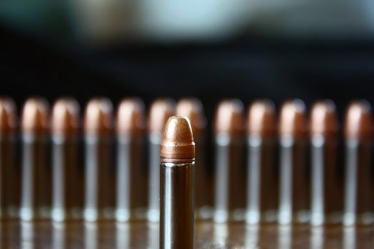 a closeup shot of a bullet with more lined up in the background