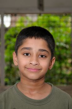 An handsome Indian kid smiling in front of the camera 